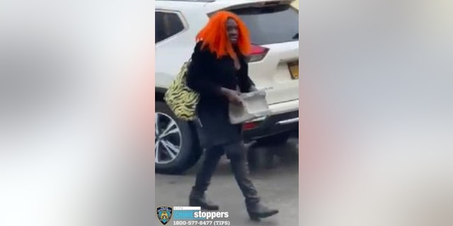 Suspect in orange wig hurls cinder block through taxi window.