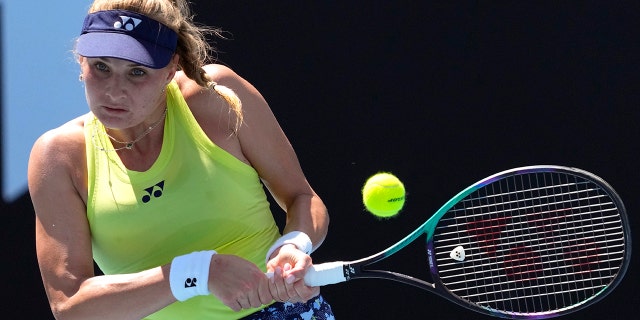 FILE - Dayana Yastremska of Ukraine plays a backhand return to Madison Brengle of the U.S. during their first round match at the Australian Open tennis championships in Melbourne, Australia, Jan. 17, 2022.