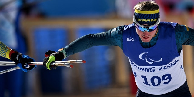 Ukrainian Paralympians rack up medals after escaping chaotic situation at home 7 Dmytro Suiarko of Ukraine grabs his poles from his guide during the men's biathlon sprint event for the visually impaired on March 5, 2022, at the Zhangjiakou National Biathlon Center during the Beijing 2022 Paralympic Winter Games.