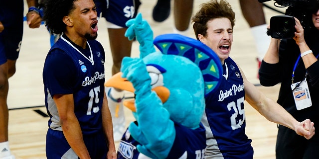 Saint Peter's Matthew Lee, left, and Doug Edert celebrate after Saint Peter's won a college basketball game against Purdue in the Sweet 16 round of the NCAA tournament, Friday, March 25, 2022, in Philadelphia.