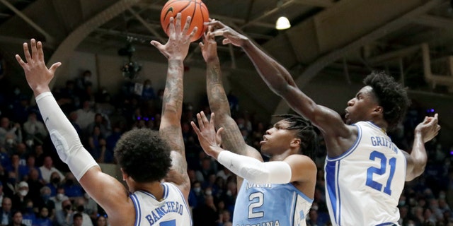 North Carolina guard Caleb Love (2) shoots against Duke forward Paolo Banchero (5) and forward AJ Griffin (21) during the first half of an NCAA college basketball game Saturday, March 5, 2022, in Durham, N.C. ()