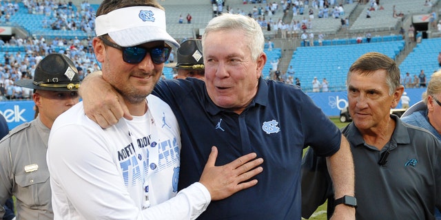 Church celebrates on the field with Tar Heels head coach Mack Brown after the Belk College Kickoff game between the South Carolina Gamecocks and the Tar Heels on Aug. 31, 2019, at Bank of America Stadium in Charlotte, North Carolina.