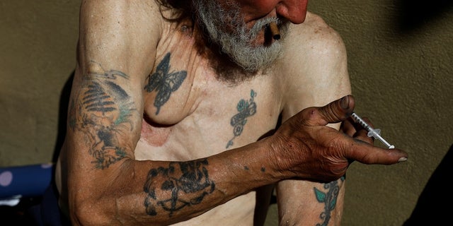 Travis Hayes, 65, injects what he says is the synthetic drug fentanyl on Feb. 27, 2020, across the street from where San Francisco mayor London Breed held a news conference introducing legislation to curb the rise of deadly overdoses in the city, at the Tenderloin section.  