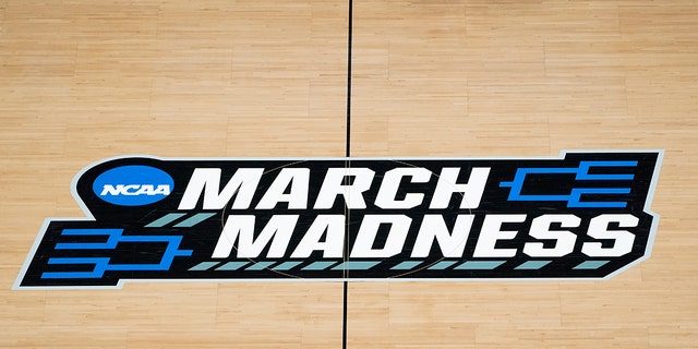 The March Madness logo on the court during the first half of a game in the first round of the NCAA Tournament at Bankers Life Fieldhouse in Indianapolis on March 20, 2021.