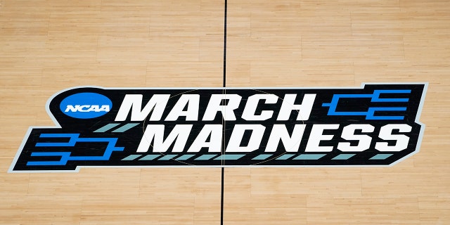 The March Madness logo on the court during the first half of a game in the first round of the NCAA Tournament at Bankers Life Fieldhouse in Indianapolis on March 20, 2021.