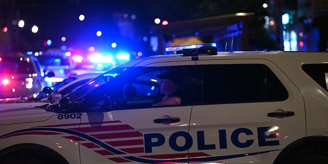 Police cars block a street after a shooting at a restaurant in Washington, D.C, on July 22, 2021.