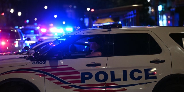 Police cars block a street after a shooting at a restaurant in Washington, D.C, on July 22, 2021.