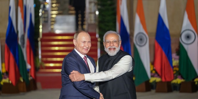 Narendra Modi, India's prime minister, right, and Vladimir Putin, Russia's president, pose for photographs as Putin arrives at Hyderabad House in New Delhi, India, on Monday, Dec. 6, 2021. 