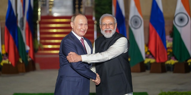 Indian Prime Minister Narendra Modi, right, and Russian President Vladimir Putin pose for photographs as Putin arrives at Hyderabad House in New Delhi, India, on Monday, Dec. 6, 2021.