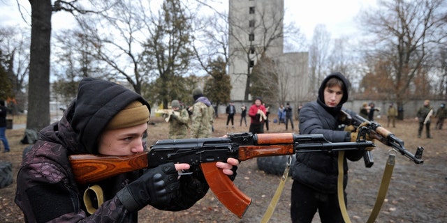 Ukrainians attend an open military training for civilians range as part of the 