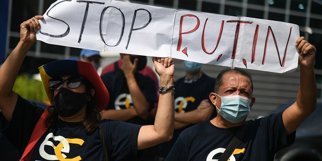Demonstrators hold a "Stop Putin" banner during a protest against Russia's invasion of Ukraine outside the European Union consulate in Caracas, Venezuela, on Thursday, March 3, 2022. 