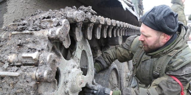 DONETSK, UKRAINE - MARCH 03: Pro-Russian separatist, in uniform without insignia repairs track of armored vehicle in the pro-Russian separatists-controlled Bugas, Donetsk, Ukraine on March 03, 2022. (Photo by Leon Klein/Anadolu Agency via Getty Images)