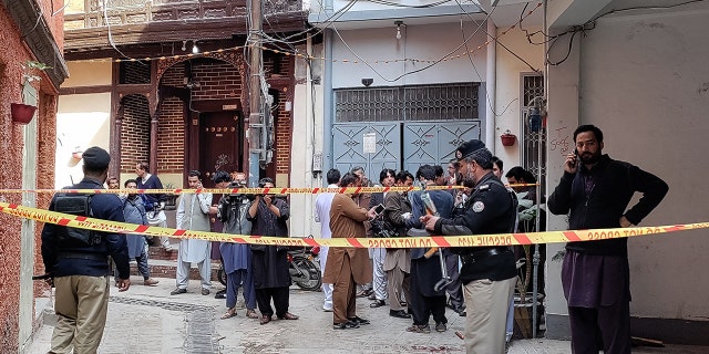 Policemen cordon off a street leading to a mosque after a bomb blast in Peshawar on March 4, 2022.