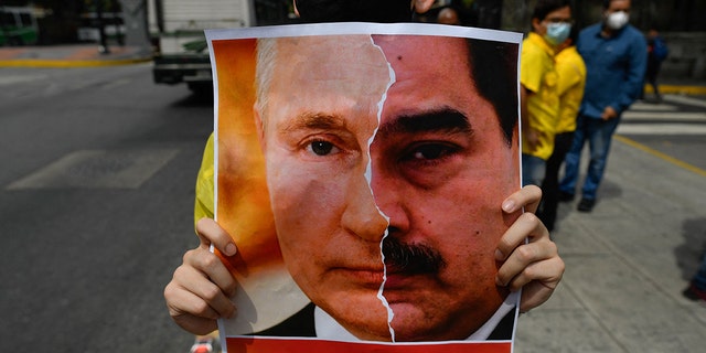 Primero Justicia tient une pancarte montrant le visage du président russe Vladimir Poutine et du président vénézuélien Nicolas Maduro 