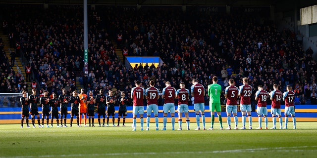 Both teams stand for a minute of applause in support of Ukraine  before the Premier League match between Burnley and Chelsea at Turf Moor on March 5, 2022 in Burnley, United Kingdom. 