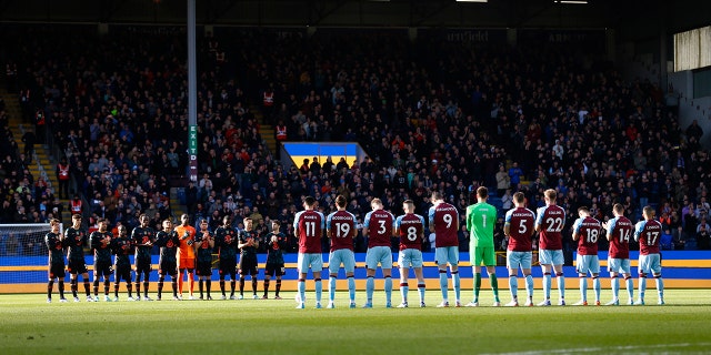 Both teams stand for a minute of applause in support of Ukraine before the Premier League match between Burnley and Chelsea at Turf Moor on March 5, 2022 in Burnley, United Kingdom.