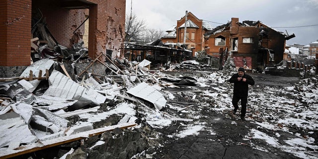 Un homme marche entre des maisons détruites lors de frappes aériennes sur la ville de Bila Tserkva, dans le centre de l'Ukraine, le 8 mars 2022.