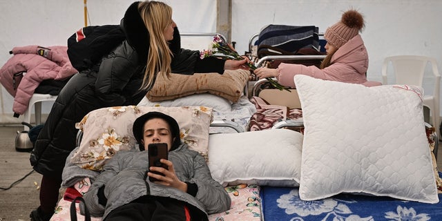 Ukrainian refugees rest in a tent upon arrival at the Romanian-Ukrainian border point.