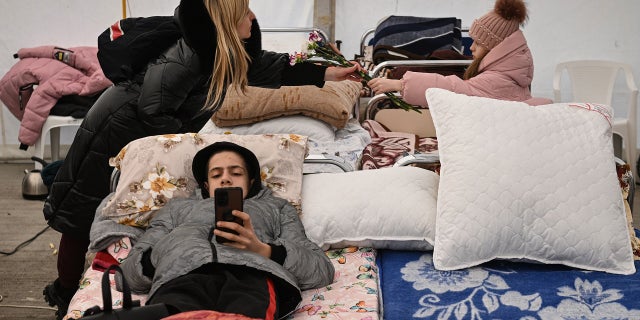 Ukrainian refugees rest in a tent upon arrival at the Romanian-Ukrainian border point.