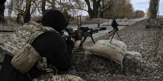 A Ukrainian serviceman aims towards Russian positions outside the city of Brovary, east of Kyiv, on March 9, 2022. 