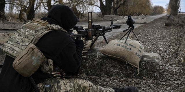 A Ukrainian serviceman aims towards Russian positions outside the city of Brovary, east of Kyiv, on March 9, 2022. 