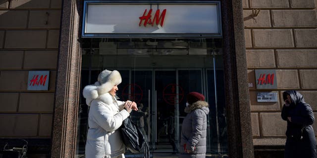 People walk past a closed H&amp;M store in Moscow on March 10, 2022, after Swedish clothing giant Hennes and Mauritz halted all sales in its Russian stores over the war in Ukraine.
