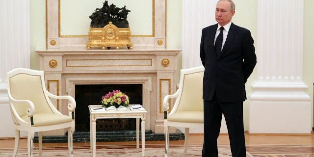 Russian President Vladimir Putin stands in a hall prior to a meeting with his Belarus counterpart at the Kremlin in Moscow on March 11, 2022.