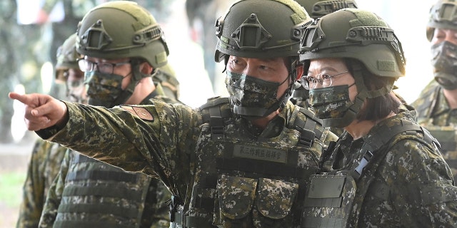 Taiwan President Tsai Ing-wen (R) listens while inspecting reservists training at a military base in Taoyuan on March 12, 2022.