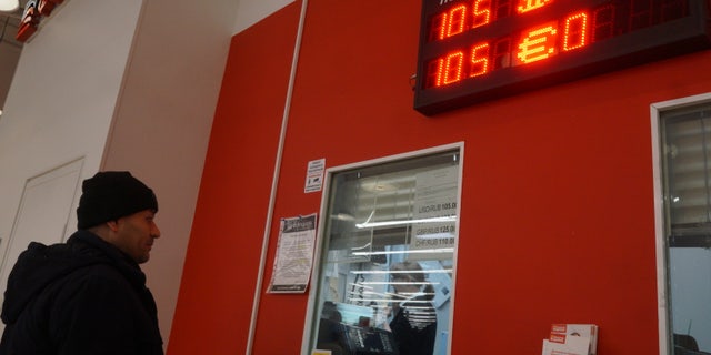 MOSCOW, RUSSIA - MARCH,15 (RUSSIA OUT): A man looks to the screen displaying the rates of U.S. Dollar and EURO to Russian Ruble at the bank at a shopping mall, March 15, 2022, in Moscow, Russia. McDonald's closed all its restaurants, KFC suspended any investment in Russia as a result of the U.S. and EU economic sanctions.