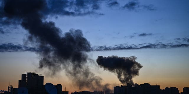 TOPSHOT - This photograph taken on March 16, 2022 shows smoke rising after an explosion in Kyiv. - Several explosions rocked Kyiv early March 16, 2022, according to AFP journalists in the city, with emergency services saying two residential buildings were damaged and two people wounded. The blasts came as Russia intensifies attacks on the Ukrainian capital, which was placed under curfew late March 15, 2022 due to what its mayor called a "difficult and dangerous moment".