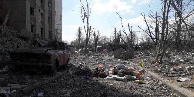 A man covers a dead body after residential buildings were hit by a Russian attack in Chernihiv, Ukraine on March 17, 2022. 