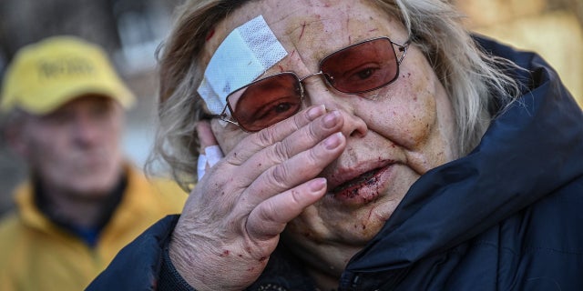 An injured woman reacts after shelling in a residential area in Kyiv March 18, 2022, as Russian troops try to encircle the Ukrainian capital as part of their slow-moving offensive.