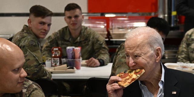 Joe Biden (right) eats pizza as he meets servicemen who are helping alongside Polish allies in deterrence on the Alliances' eastern flank, in the town of Rzeszow, about 100 kilometers (62 miles) from the border with Ukraine.
