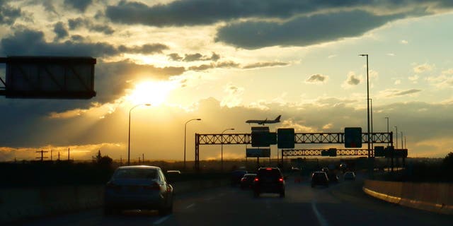FILE - An airplane flies over the New Jersey Turnpike while landing at Newark Liberty International Airport as the sun sets on May 11, 2021, in Newark, New Jersey. 