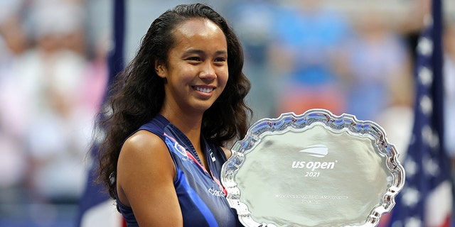 Leylah Annie Fernandez of Canada celebrates with the second trophy after being defeated by Emma Raducanu of Great Britain in their women's singles <a class=
