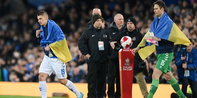 Vitaliy Mykolenko of Everton leads his team out to the field of play wearing the Ukrainian flag around him prior to the Emirates FA Cup Fifth Round match between Everton and Boreham Wood at Goodison Park March 3, 2022, in Liverpool, England.