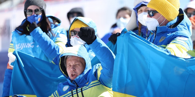 Members of Team Ukraine show support as they celebrate Grygorii Vovchynskyi (not pictured) of Team Ukraine winning gold in the men's sprint standing Paralympic biathlon during Day One of the Beijing 2022 Winter Paralympics at Zhangjiakou National Biathlon Centre March 5, 2022, in Beijing.