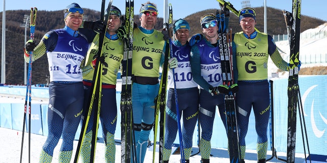 Oleksandr Kazik of Team Ukraine and his guide Serhii Kucheriavyi, Vitalii Lukianenko of Team Ukraine and his guide Borys Babar and Dmytro Suiarko and his guide Oleksandr Nikonovych of Team Ukraine pose following the men's sprint vision-impaired biathlon at the Beijing 2022 Winter Paralympics at Zhangjiakou National Biathlon Centre March 5, 2022.