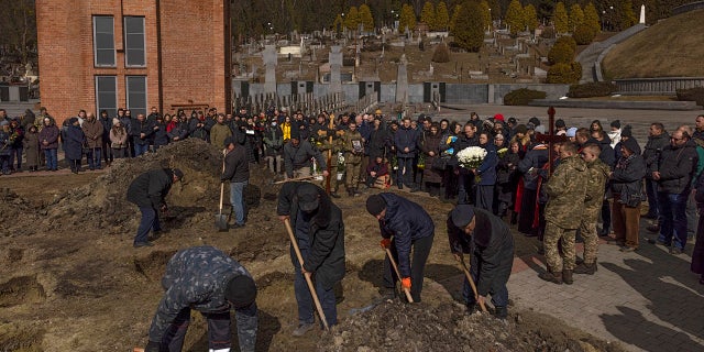 A service for two soldiers who died fighting in the eastern part of Ukraine takes place at Lychakiv cemetery on March 8, 2022, in Lviv.