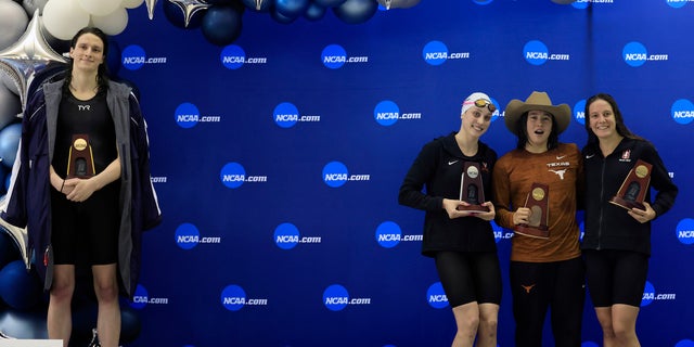 Transgender athlete Lia Thomas, left, of the University of Pennsylvania, steps onto the podium after winning the 500-yard freestyle while fellow medalists - from second left, Emma Weyant, Erica Sullivan and Brooke Forde – pose for a photo at the NCAA Division I Women's Swimming and Diving Championships, March 17, 2022 in Atlanta.  (Getty Images)