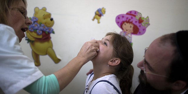 An Israeli child receives a vaccination against Polio at a clinic in Jerusalem on Aug.  18, 2013. (AFP PHOTO / MENAHEM KAHANA)