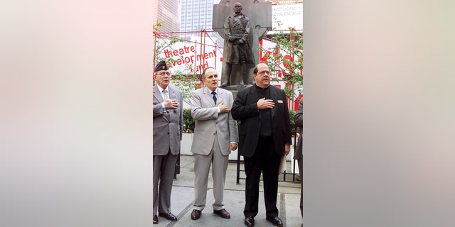 Mayor Rudy Giuliani is flanked by Joseph Healy, former commanding officer of the 69th New York Infantry, and the Rev. Peter Colapietro, pastor of Holy Cross Church, at ceremony to rededicate the Father Duffy Memorial in Times Square. Circa 2000.