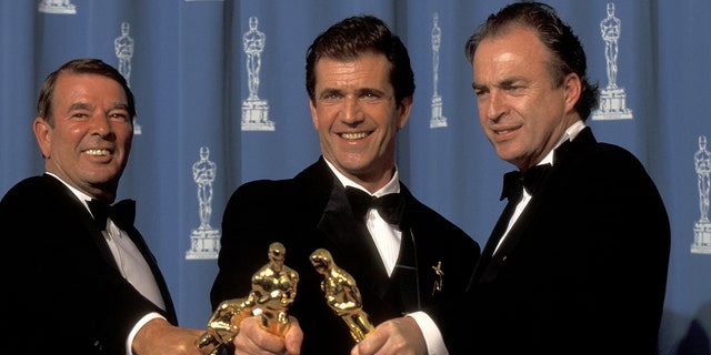 From left: Alan Ladd Jr., Mel Gibson, and Bruce Davey at the Dorothy Chandler Pavilion in Los Angeles, California with their Oscars.
