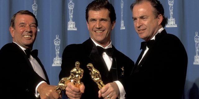 From left: Alan Ladd Jr., Mel Gibson, and Bruce Davey at the Dorothy Chandler Pavilion in Los Angeles, California with their Oscars.