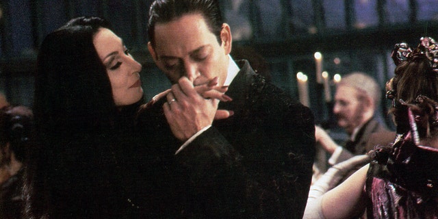 Anjelica Huston is kissed by Raul Julia in a scene from the film 'The Addams Family', 1991. 