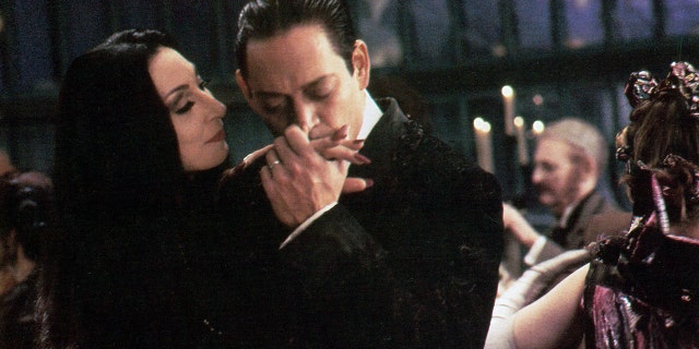 Anjelica Huston is kissed by Raul Julia in a scene from the film 'The Addams Family', 1991. 