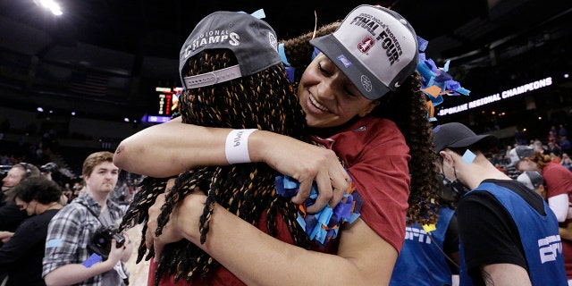Stanford guard Haley Jones, 对, wears a Final Four ball cap as she hugs forward Francesca Belibi, 剩下, after a college basketball game against Texas in the Elite 8 round of the NCAA tournament, 星期日, 游行 27, 2022, in Spokane, 洗. Stanford won 59-50.
