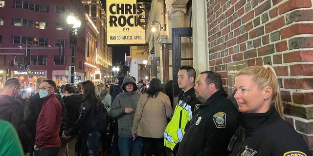 Fans and police officers stand outside Chris Rock's show in Boston, Massachusetts.