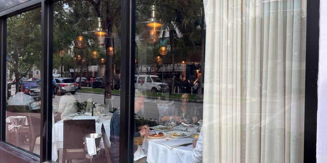 Diners enjoy a meal at Papi Steak on First Street in Miami Beach Friday, March 25.