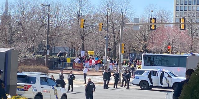 Protesters gather outside the Hilton hotel housing the House Democrats' member retreat as President Biden addresses the conference.